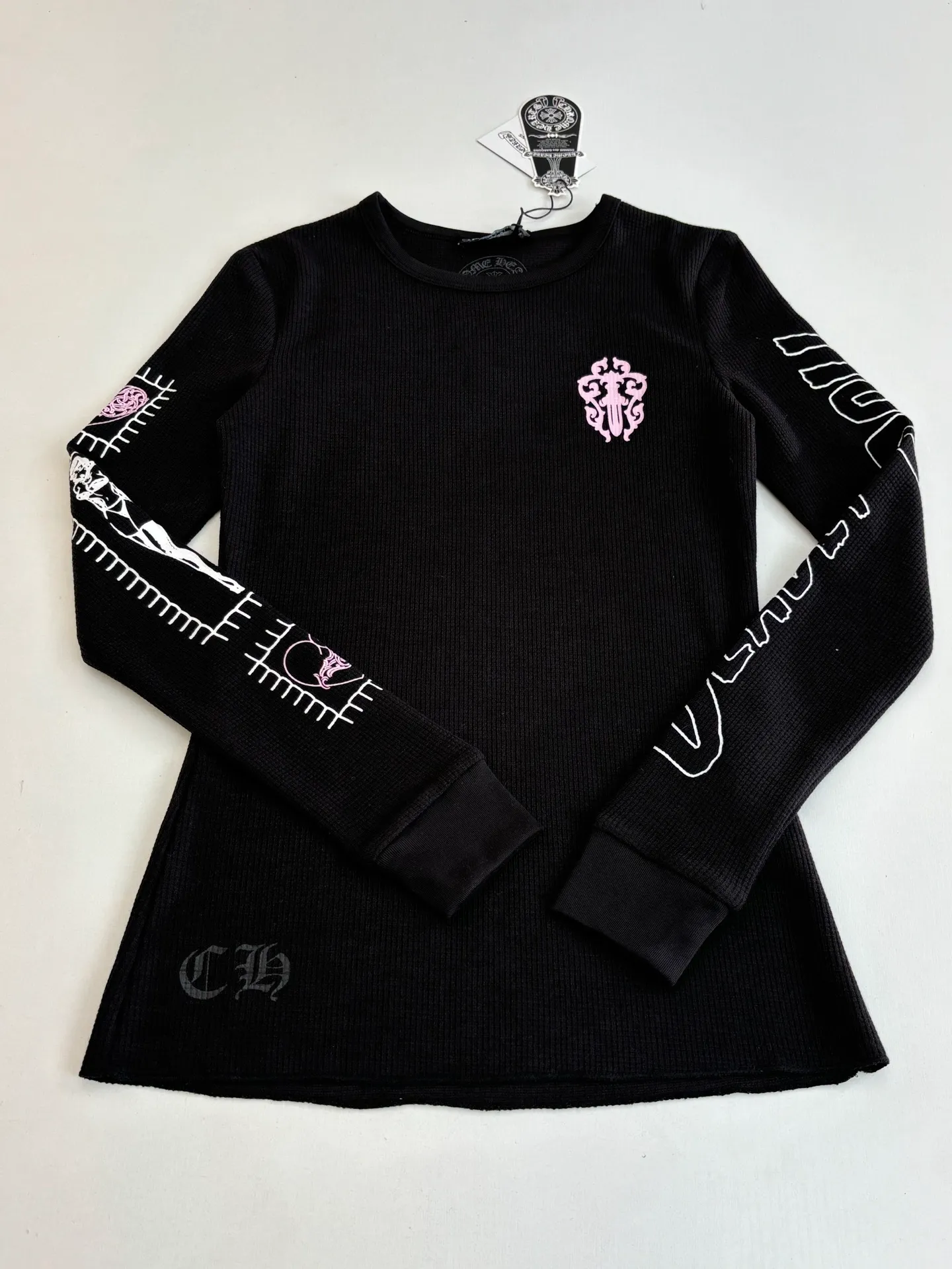 P266 (Slim fit women's style) Chrome Heart*/Ch character Sanskrit printed waffle long-sleeved T-shirt is woven with 32-count blended yarn. The fabric composition is 30% cotton and 70% polyester, with a weight of 220 grams. It ensures a stiff fit while taking into account the skin-friendly properties of cotton fiber and the anti-wrinkle and easy-care properties of polyester. The body of the garment adopts a waffle knitted structure, forming a three-dimensional texture and good breathability and moisture removal. Screen printing technology is used in the printing process to accurately present the brand's iconic Gothic fonts, totem patterns and character patterns on the front, back and sleeves of the garment. The printing layer has strong adhesion and the pattern outline is clear. Size: S/M/L